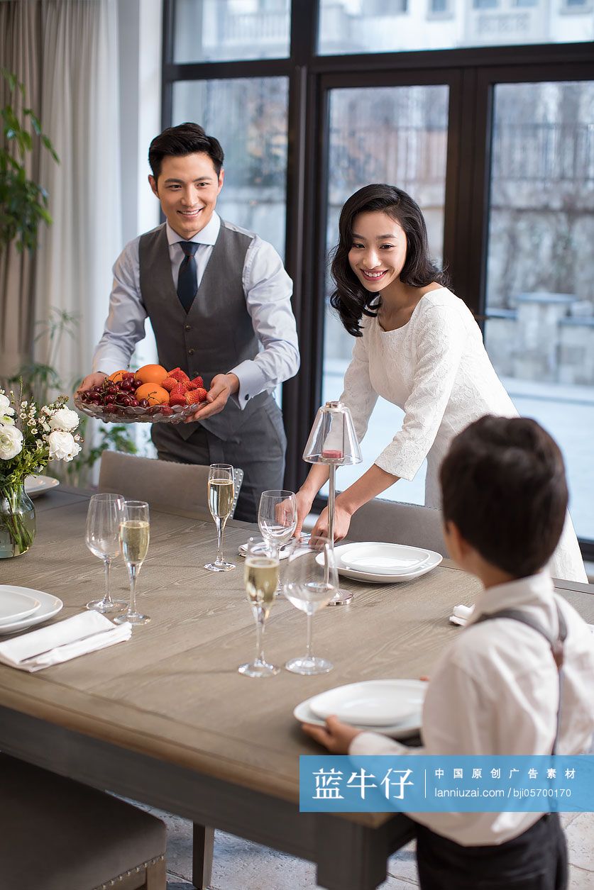 幸福的年轻贵族家庭一起摆餐具