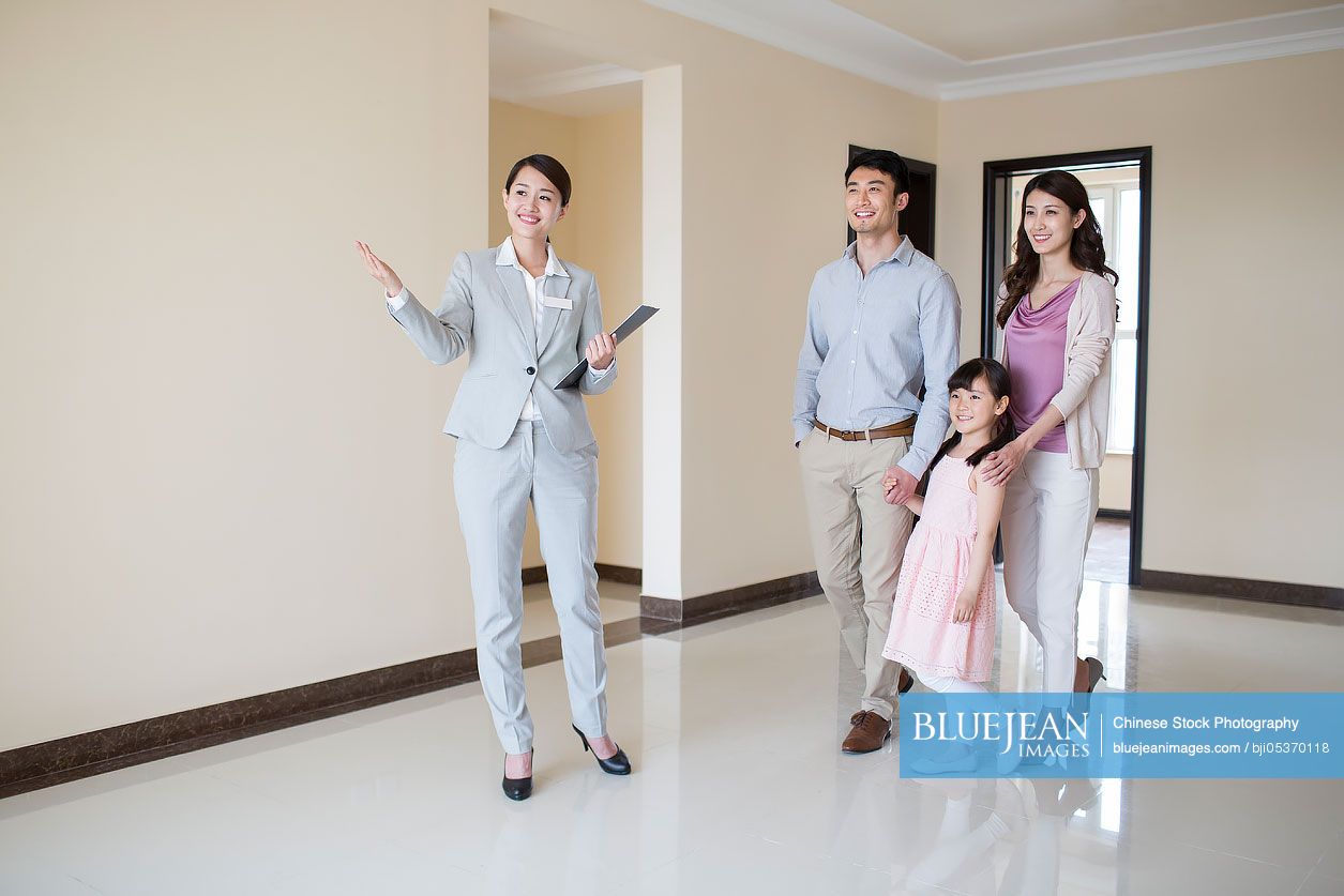 Chinese realtor showing new house to young family