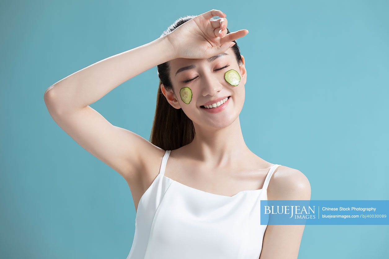 Beautiful young Chinese woman with cucumber slices