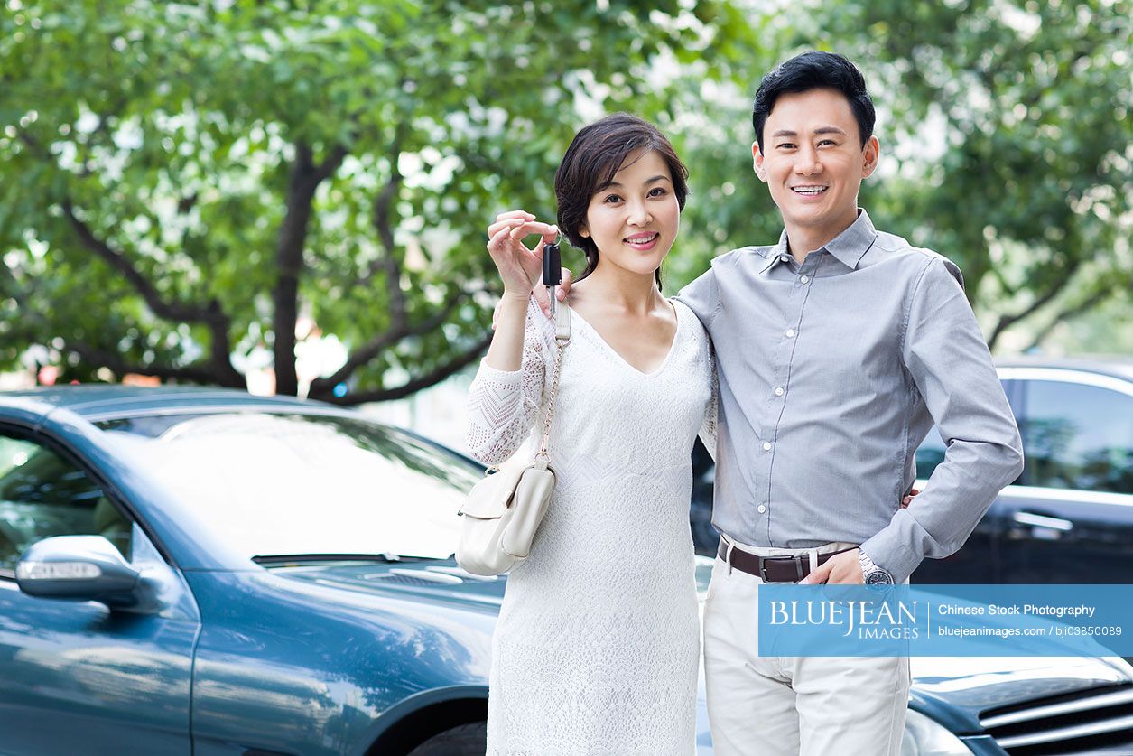 Happy Chinese couple showing car key