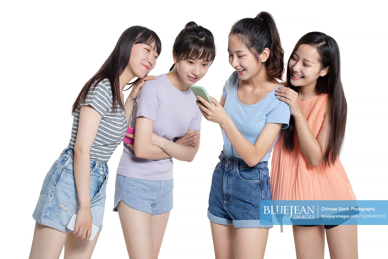 Cheerful Chinese college students using smart phone