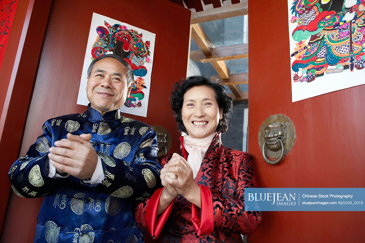 Happy senior Chinese man and woman wearing traditional clothing