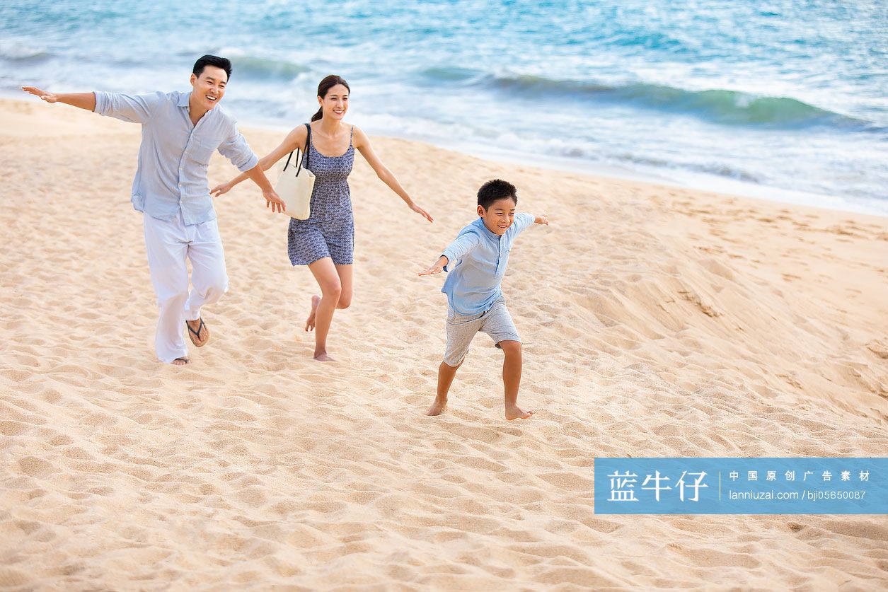 快乐的年轻家庭在沙滩玩耍