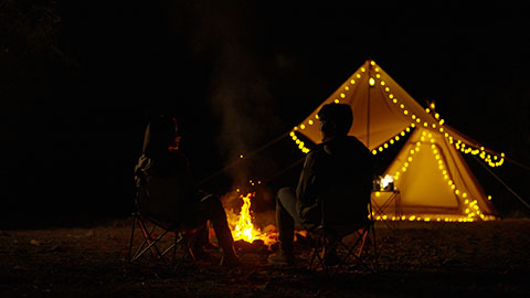 Happy young Chinese couple camping outdoors