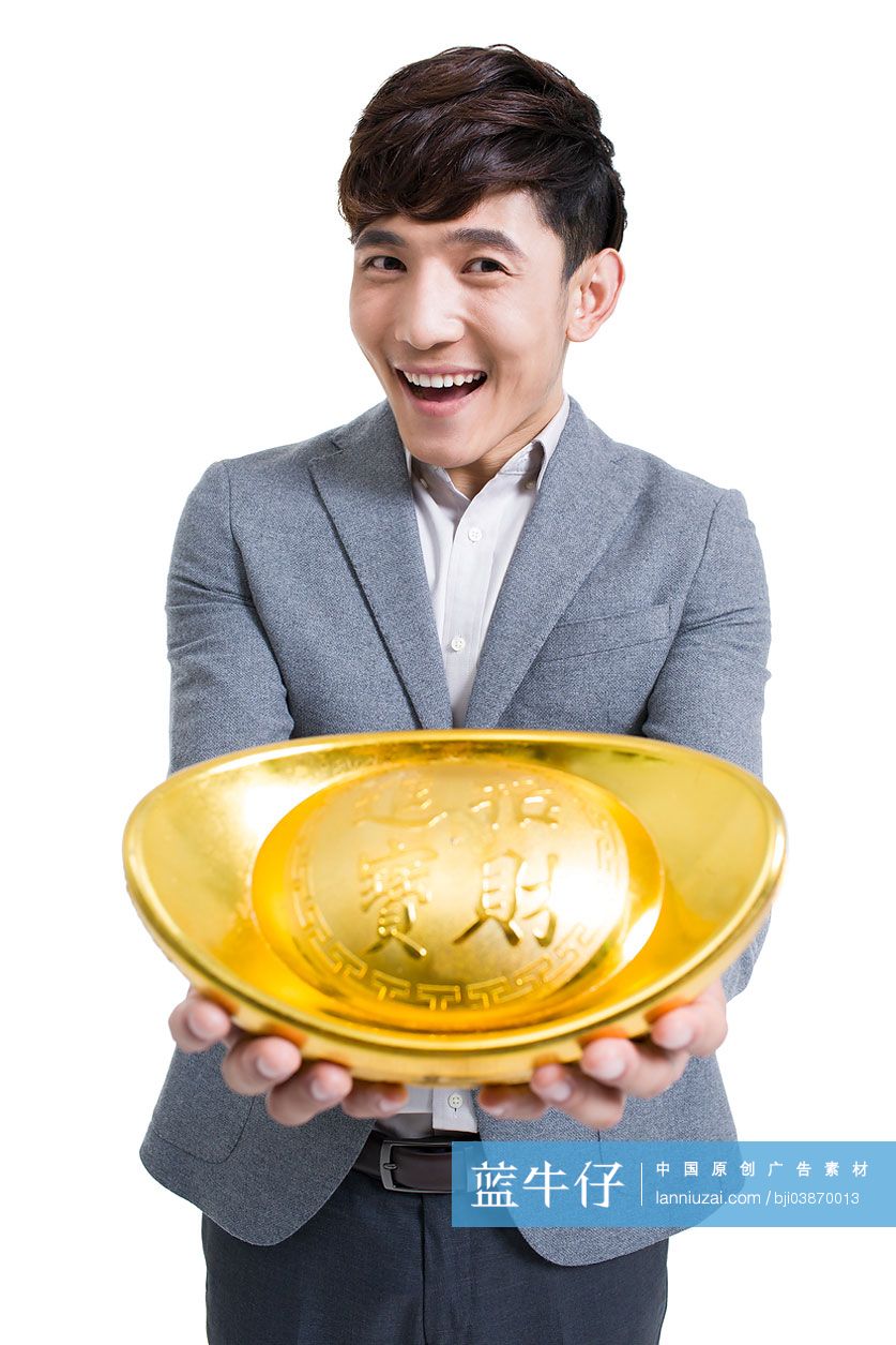 快乐的年轻男子抱着一个金元宝