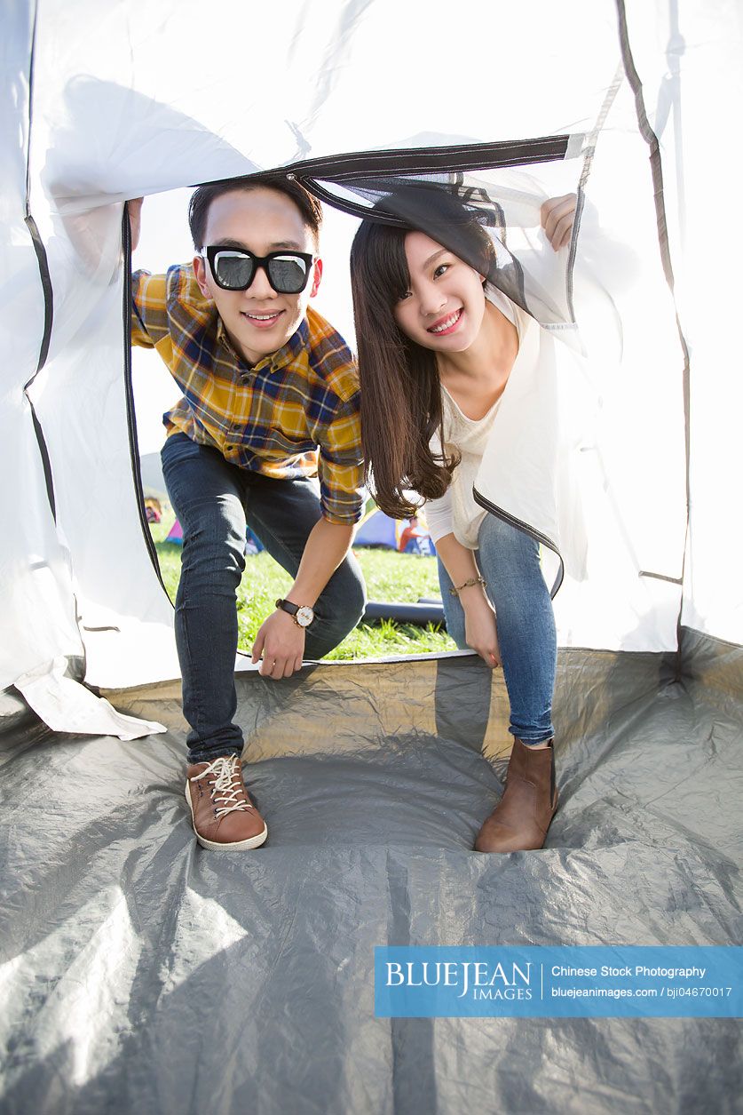 Young Chinese couple entering a tent