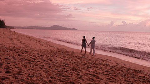Young Chinese couple walking on beach at sunset,4K