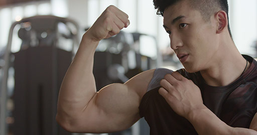 Young Chinese man flexing muscles at gym,4K