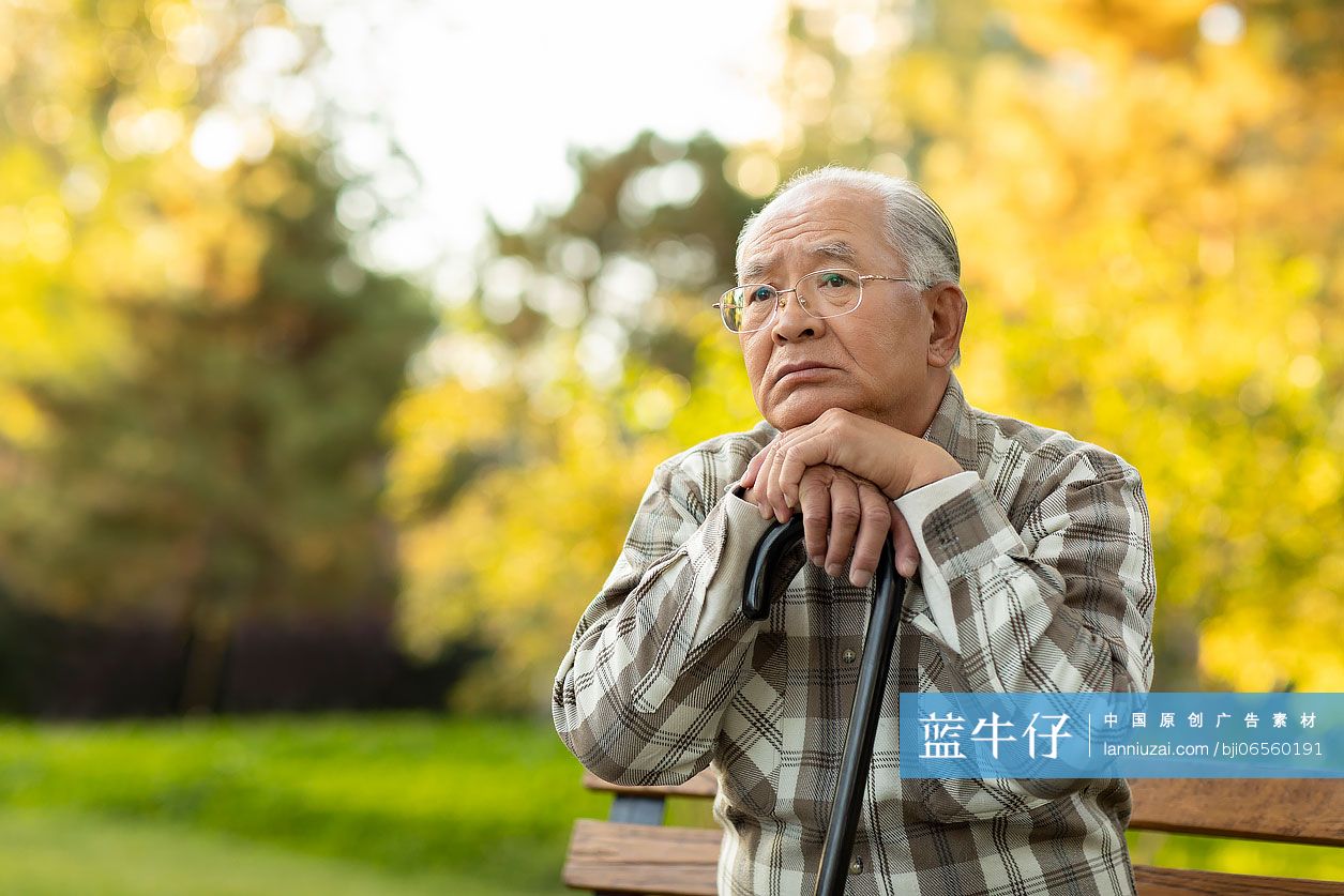 孤独的老人坐在公园长椅上