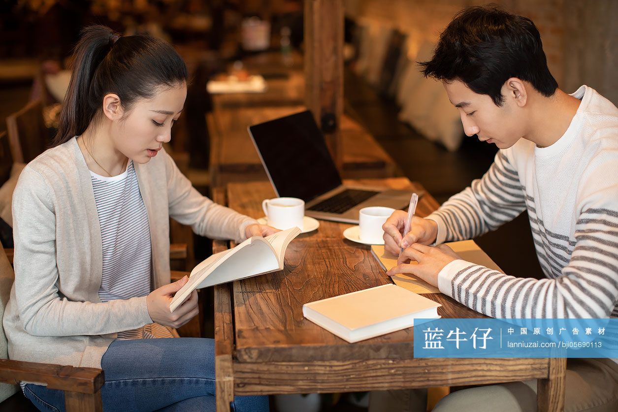 年轻大学生在咖啡店学习