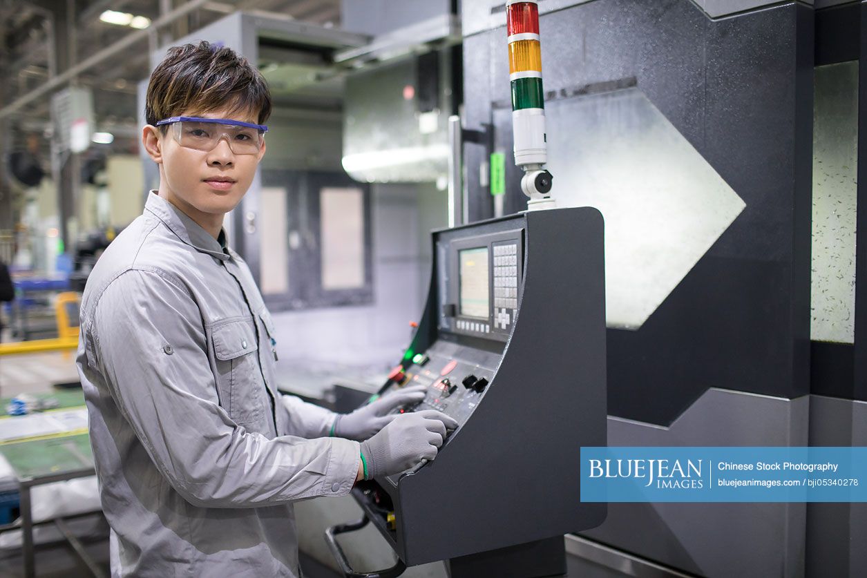 Confident Chinese engineer working in the factory