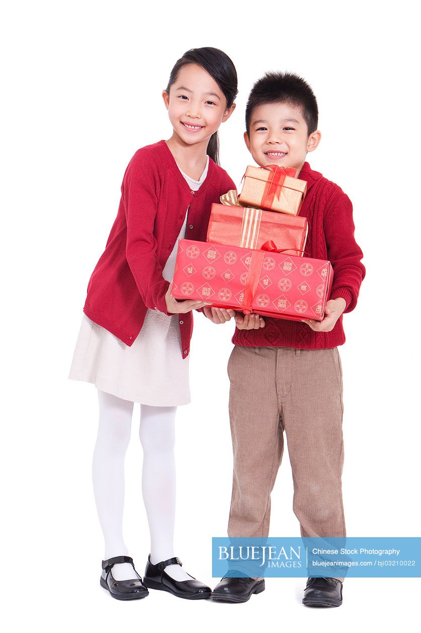 Happy Chinese boy and girl holding gift boxes