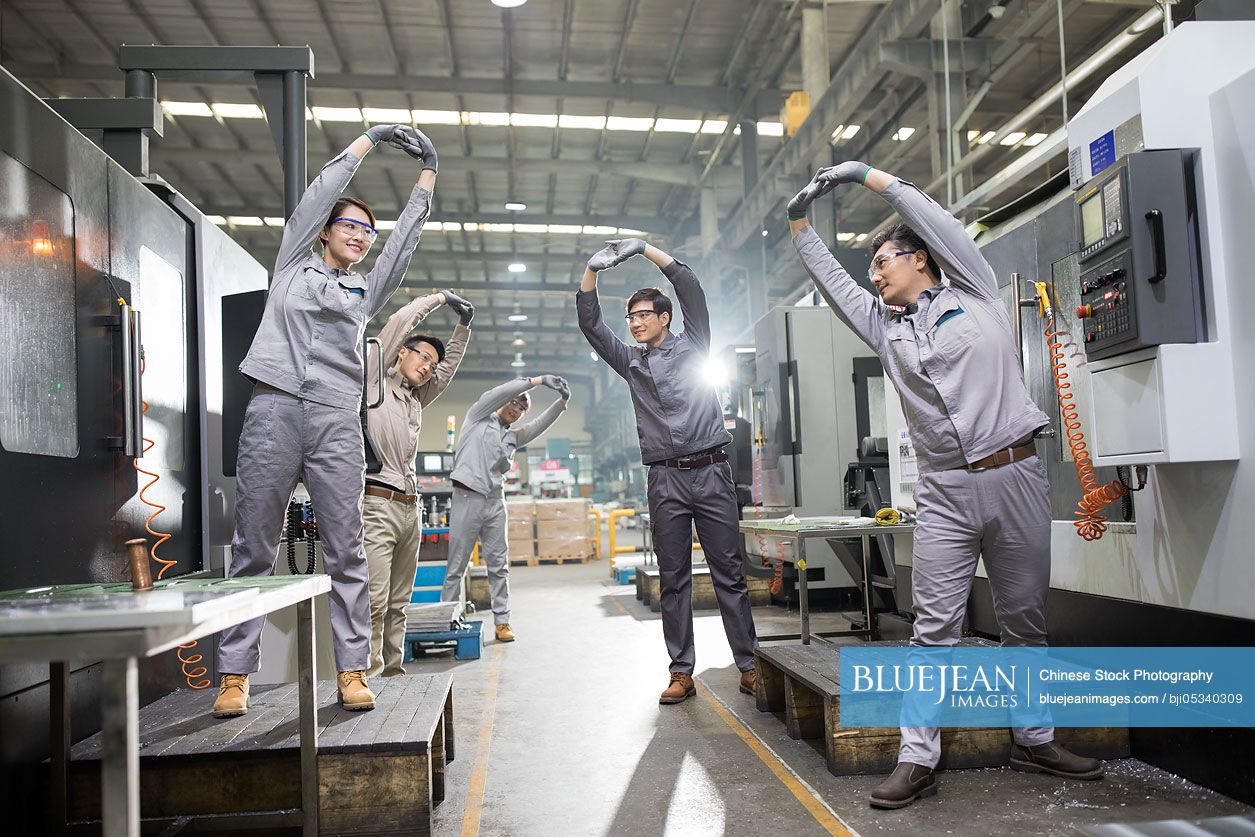 Chinese engineers stretching in the factory