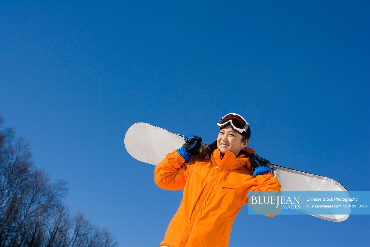 Young Chinese woman with her snowboard