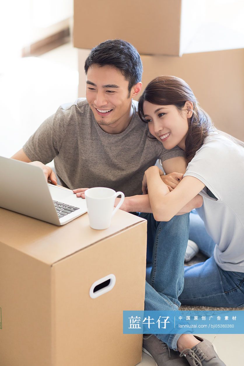 年轻夫妇在新房里使用笔记本电脑-蓝牛仔影像-中国原创广告影像素材