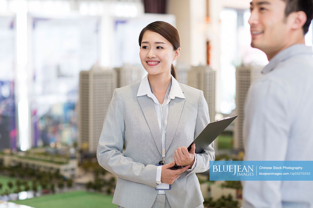 Confident Chinese realtor talking with customerHighres stock photo