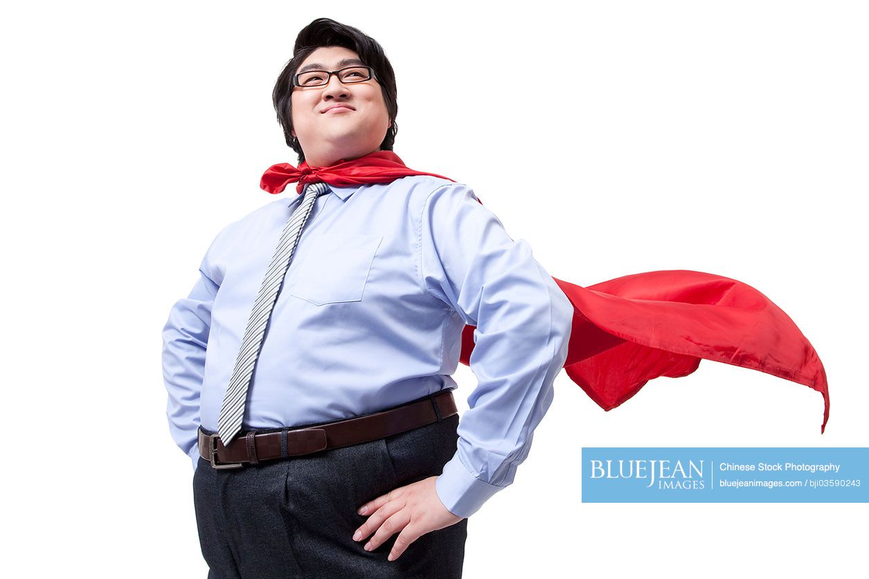 Overweight businessman playing the part of superman