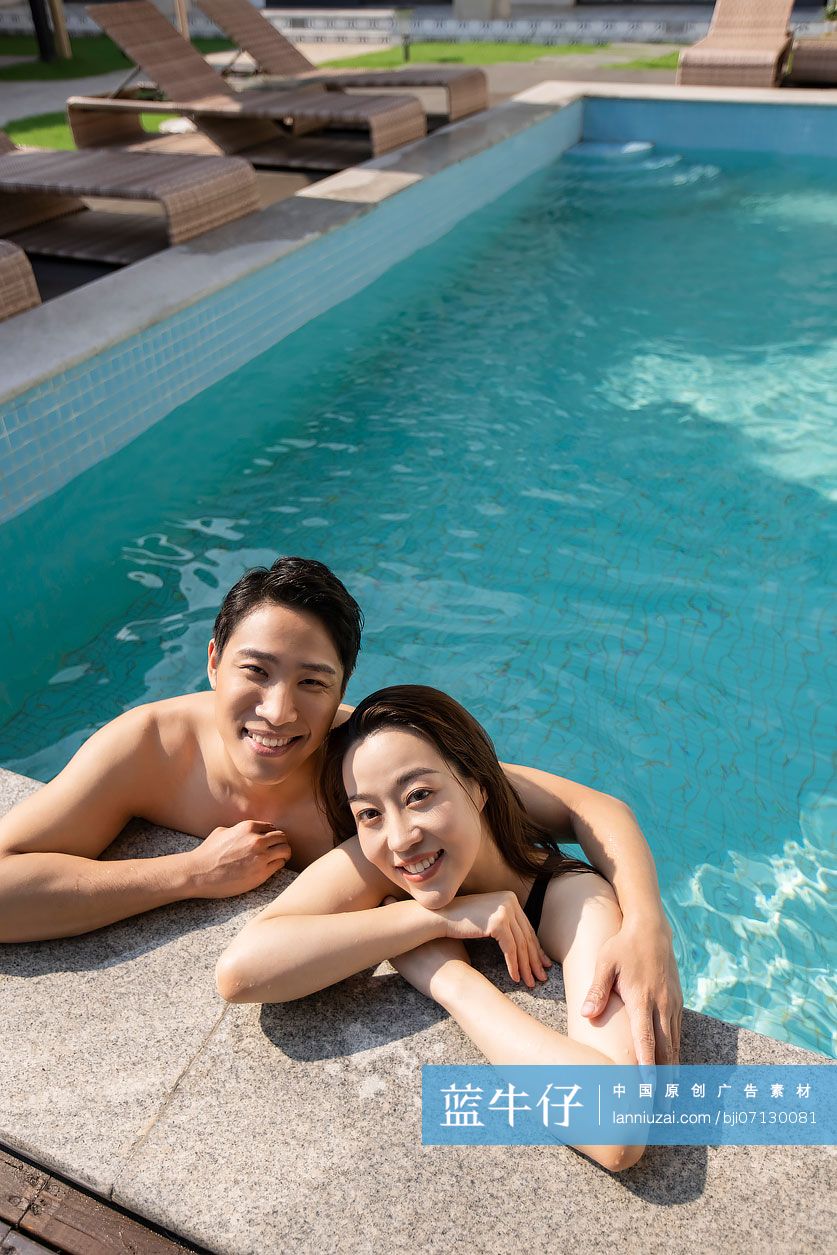 快乐的年轻情侣趴在泳池边