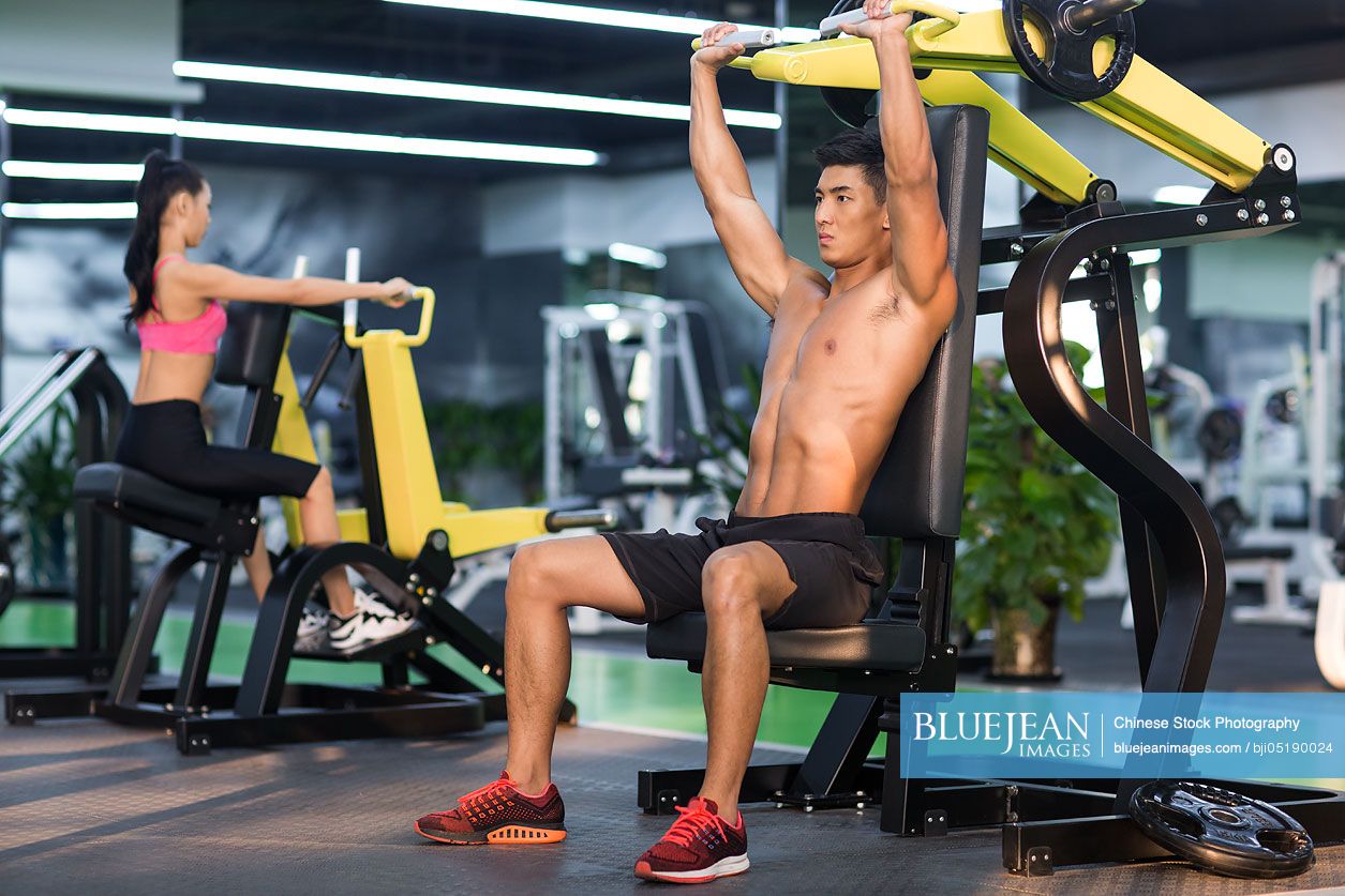 Young Chinese man exercising at gym