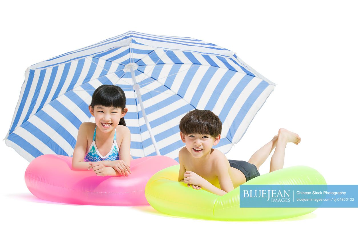 Cute Chinese children in swimsuit with swim rings