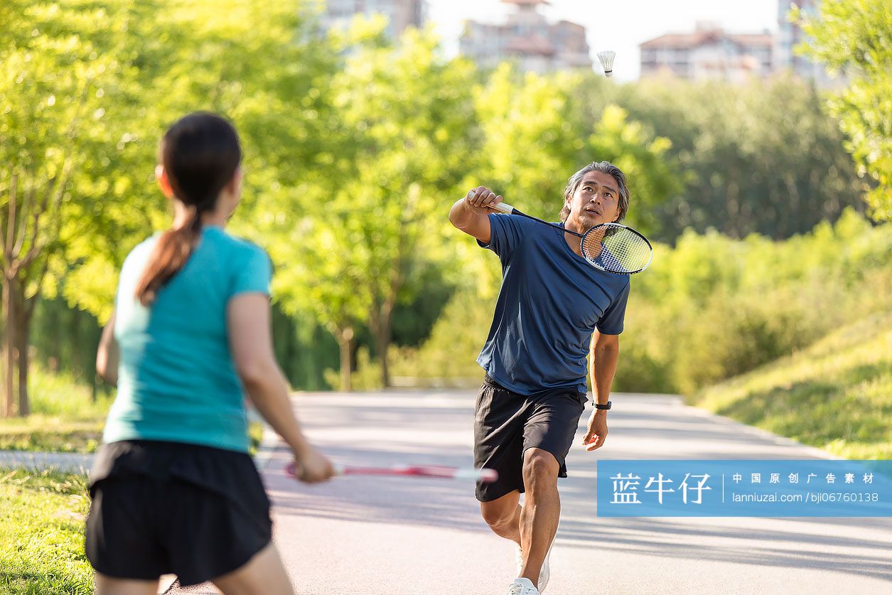 开心的中老年夫妇在户外打羽毛球