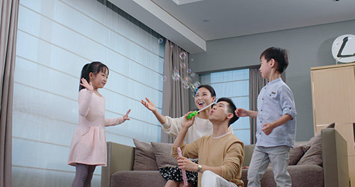 Young family playing with bubbles in living room,4K