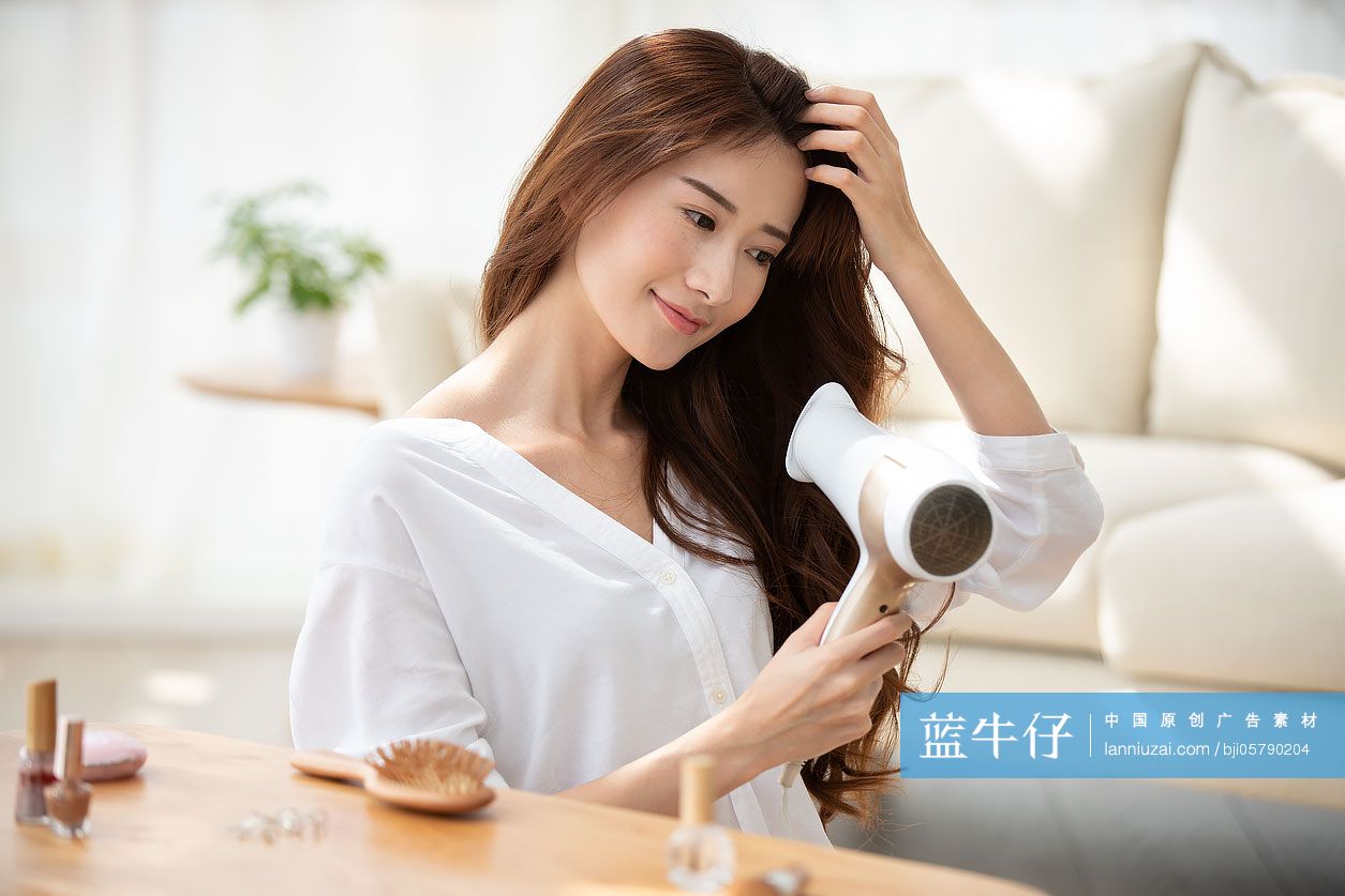 年轻女士在家吹头发