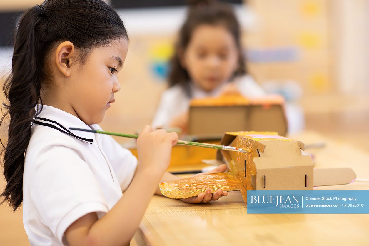 Little Chinese girls having art class in classroom