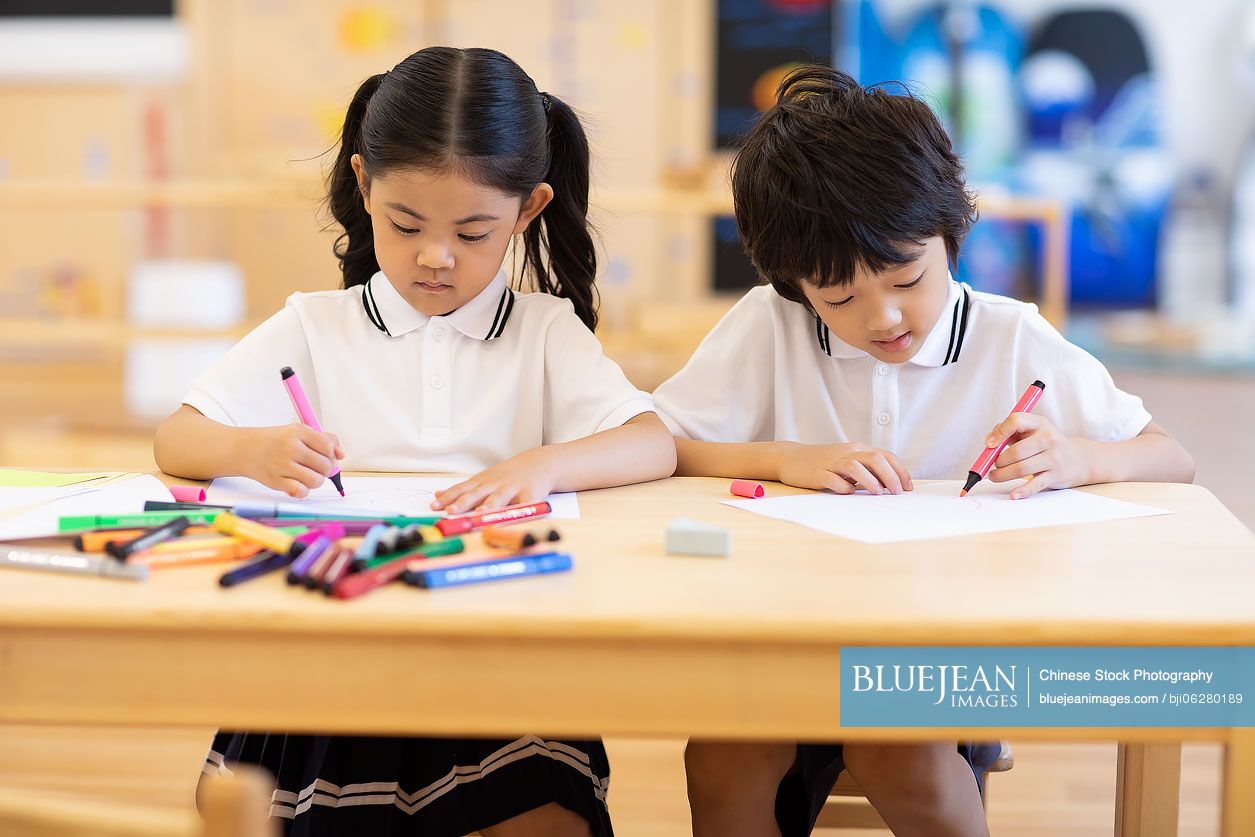 Chinese children painting in classroom