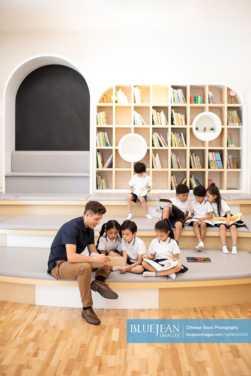 Children reading book in library