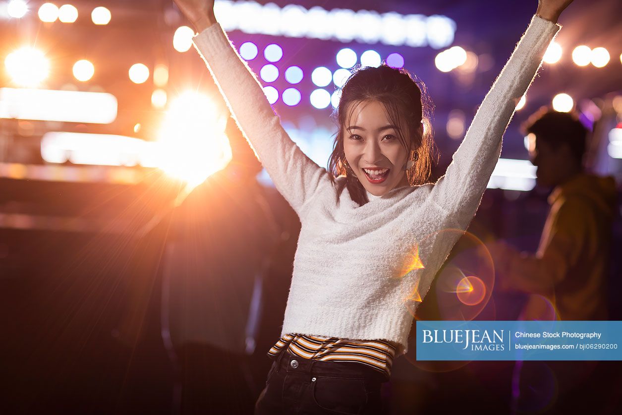 Happy young Chinese friends having fun at music festival