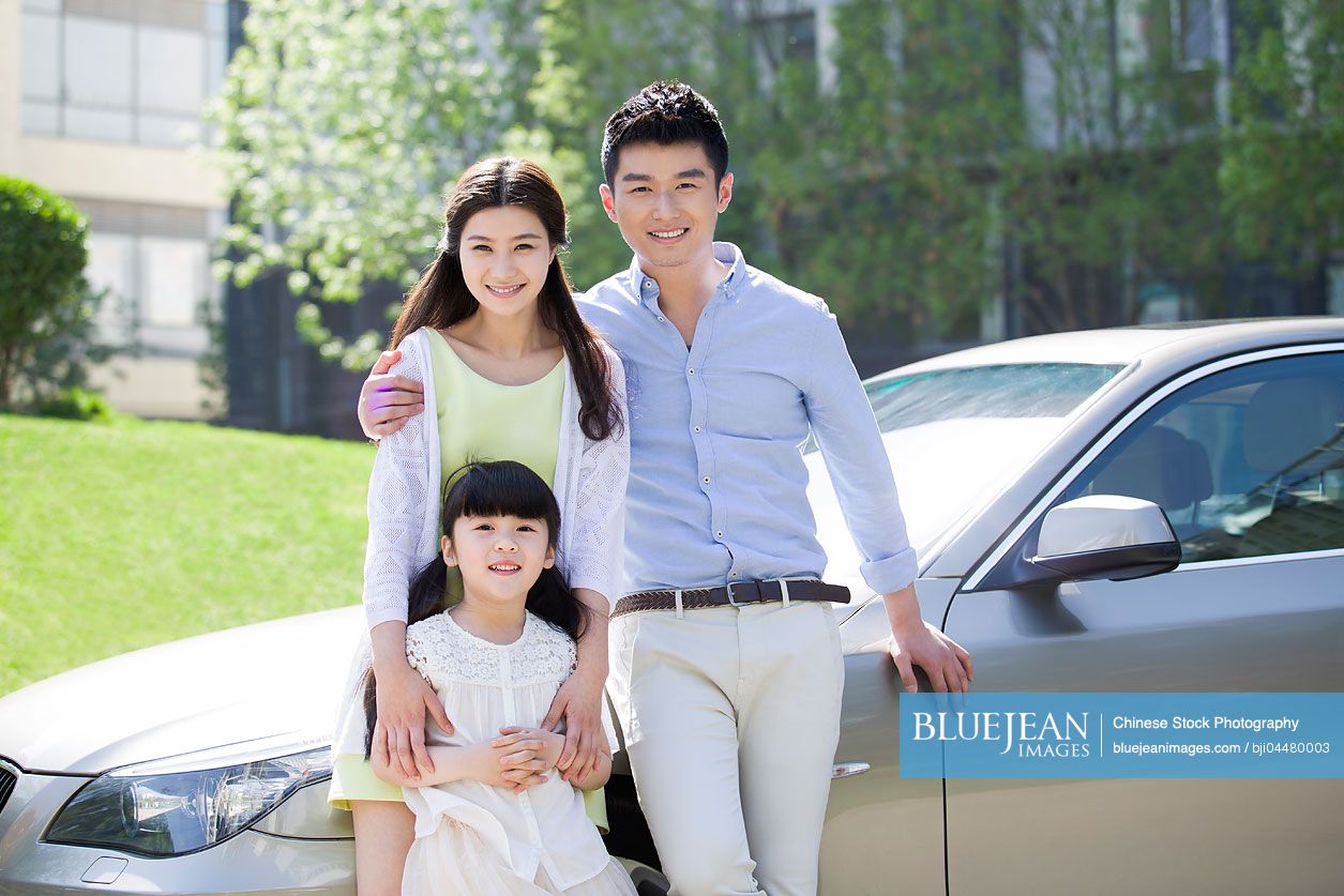 Happy young Chinese family and car