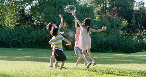 快乐儿童在草坪上吹泡泡