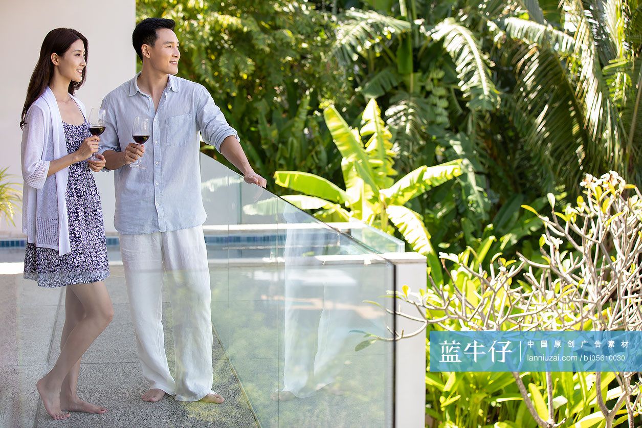 年轻夫妇在露台喝红酒