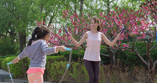 快乐的年轻家庭在公园跳绳