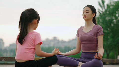 妈妈和女儿在公园练瑜伽