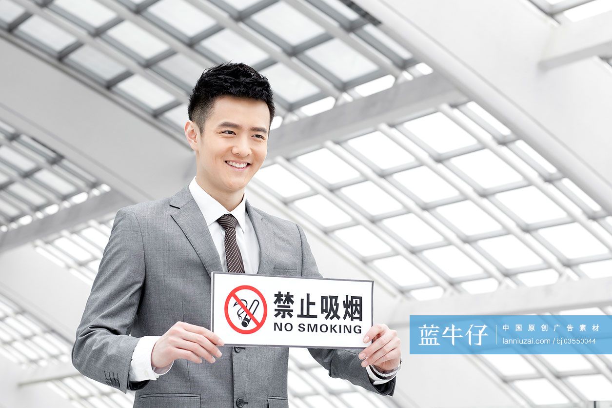 商务男士拿着“禁止吸烟”标语