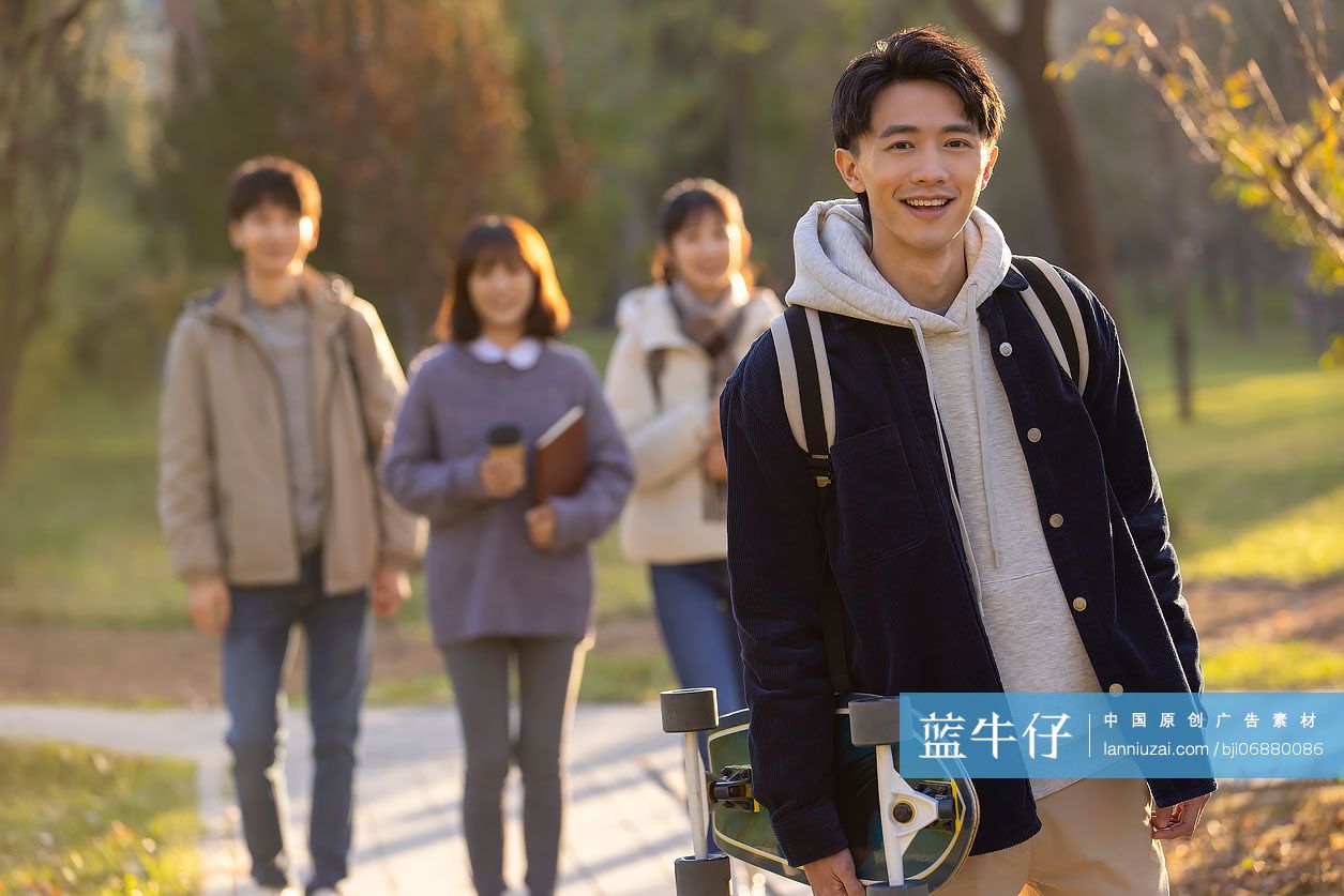 校园里拿着滑板的大学生