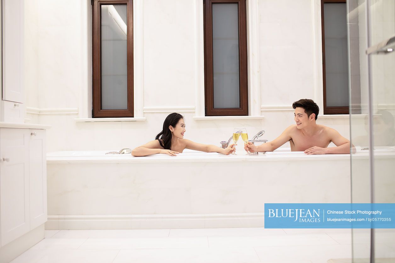 Happy young Chinese couple taking a bath at home
