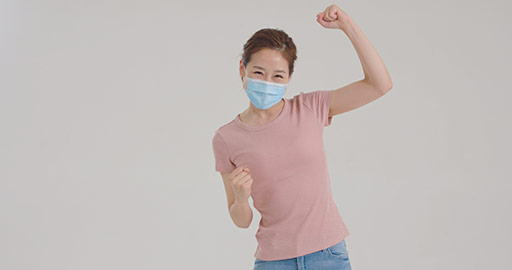 Young Chinese woman with surgical mask punching the air,4K