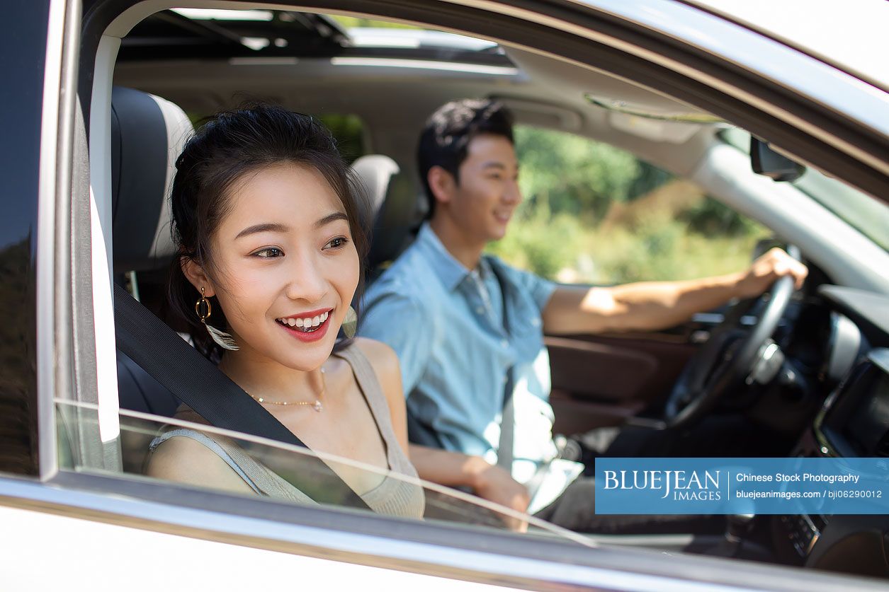 Happy young Chinese couple enjoying road trip