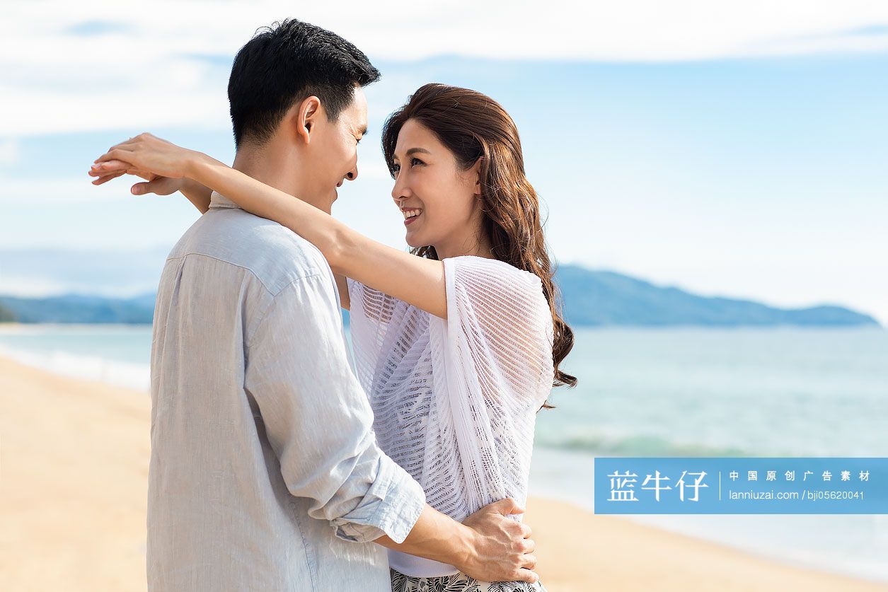 快乐的年轻夫妇在沙滩拥抱