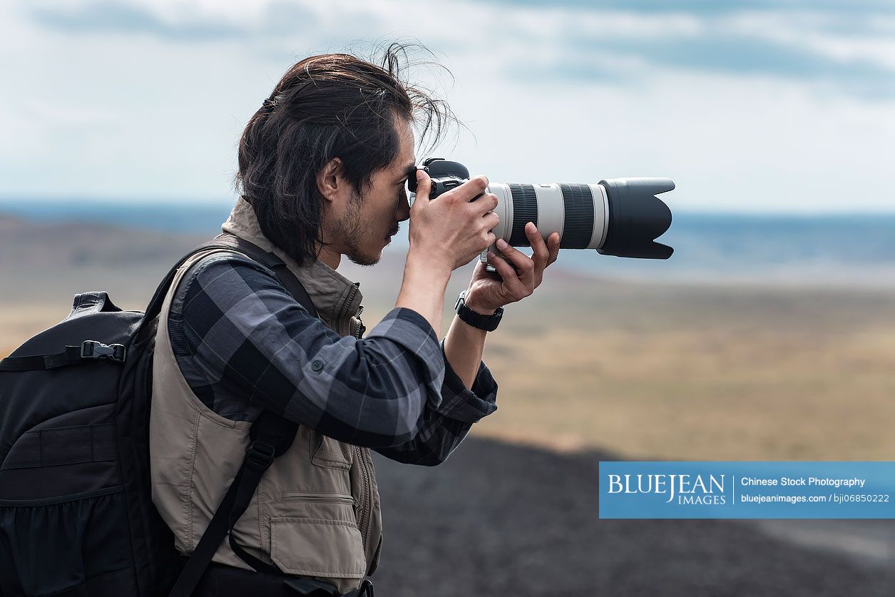 Chinese male photographer taking photos outdoors