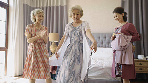 Senior Chinese friends choosing dresses in the bedroom,4K