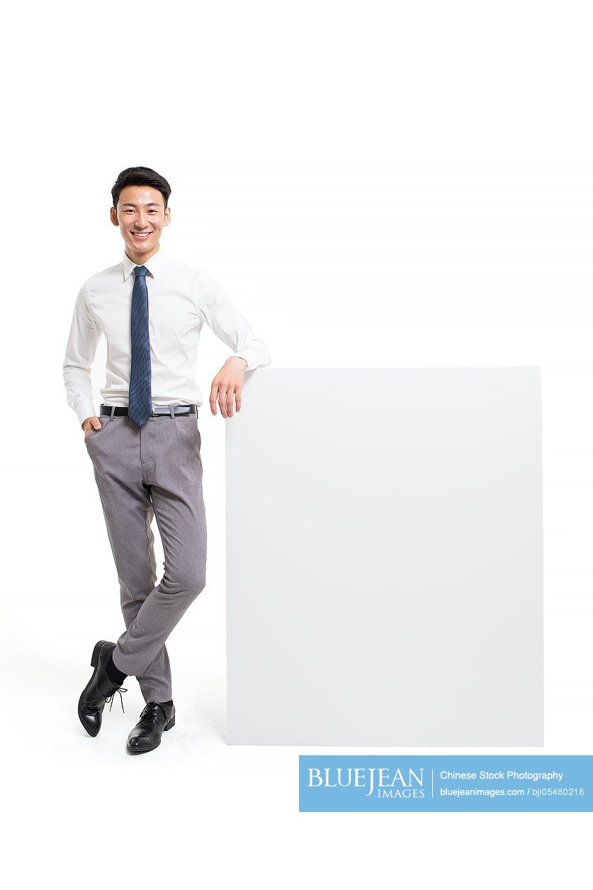 Cheerful young Chinese businessman showing a whiteboard