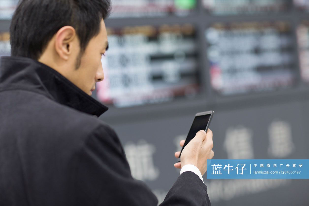 年轻商务男士在机场使用手机