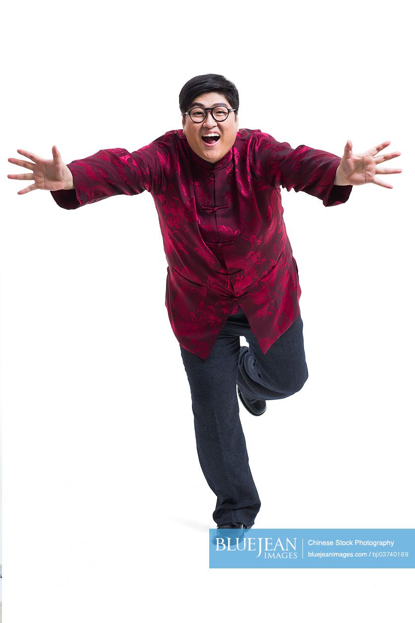 Excited Chinese young man in Tang suit reaching out