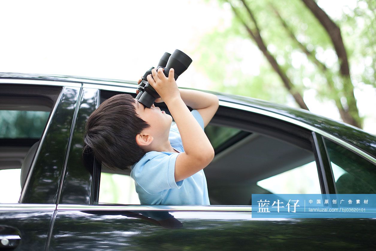 小男孩用望远镜看车窗外