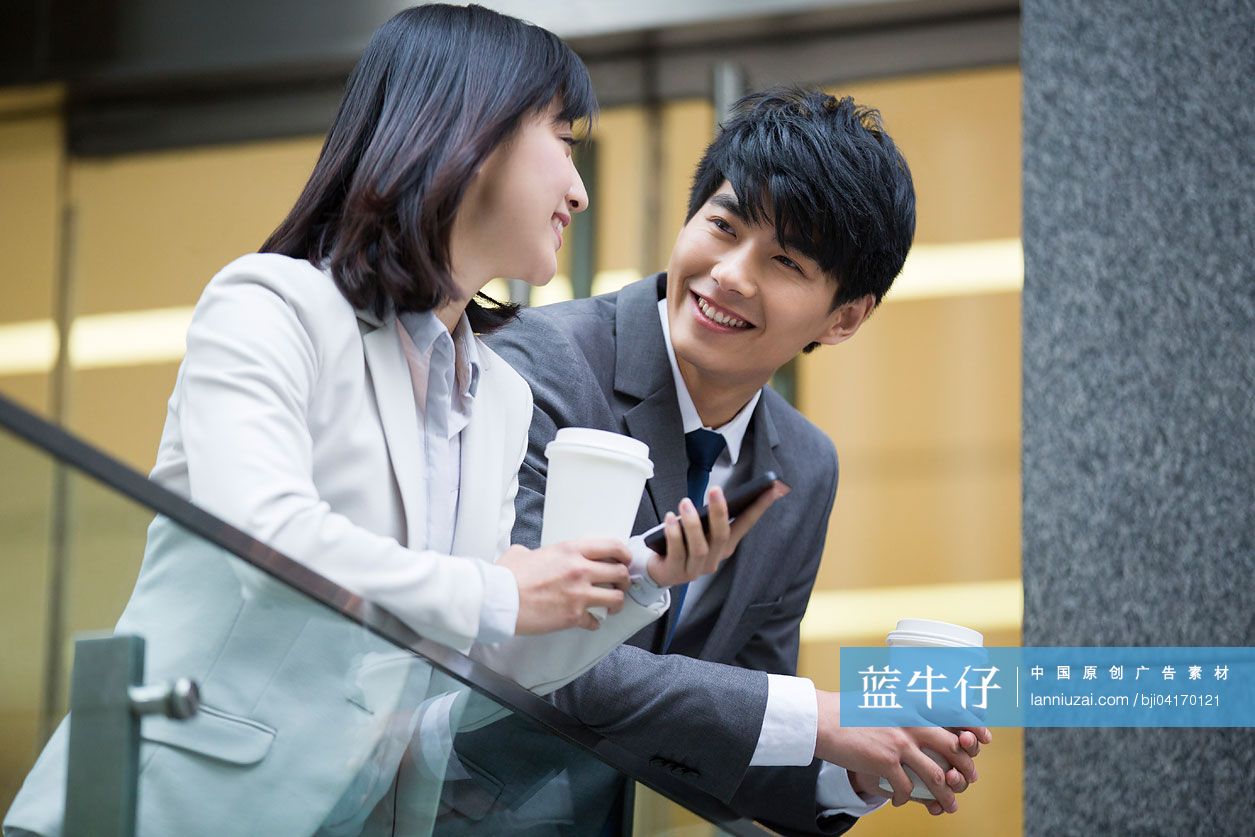 年轻商务男女拿着咖啡杯