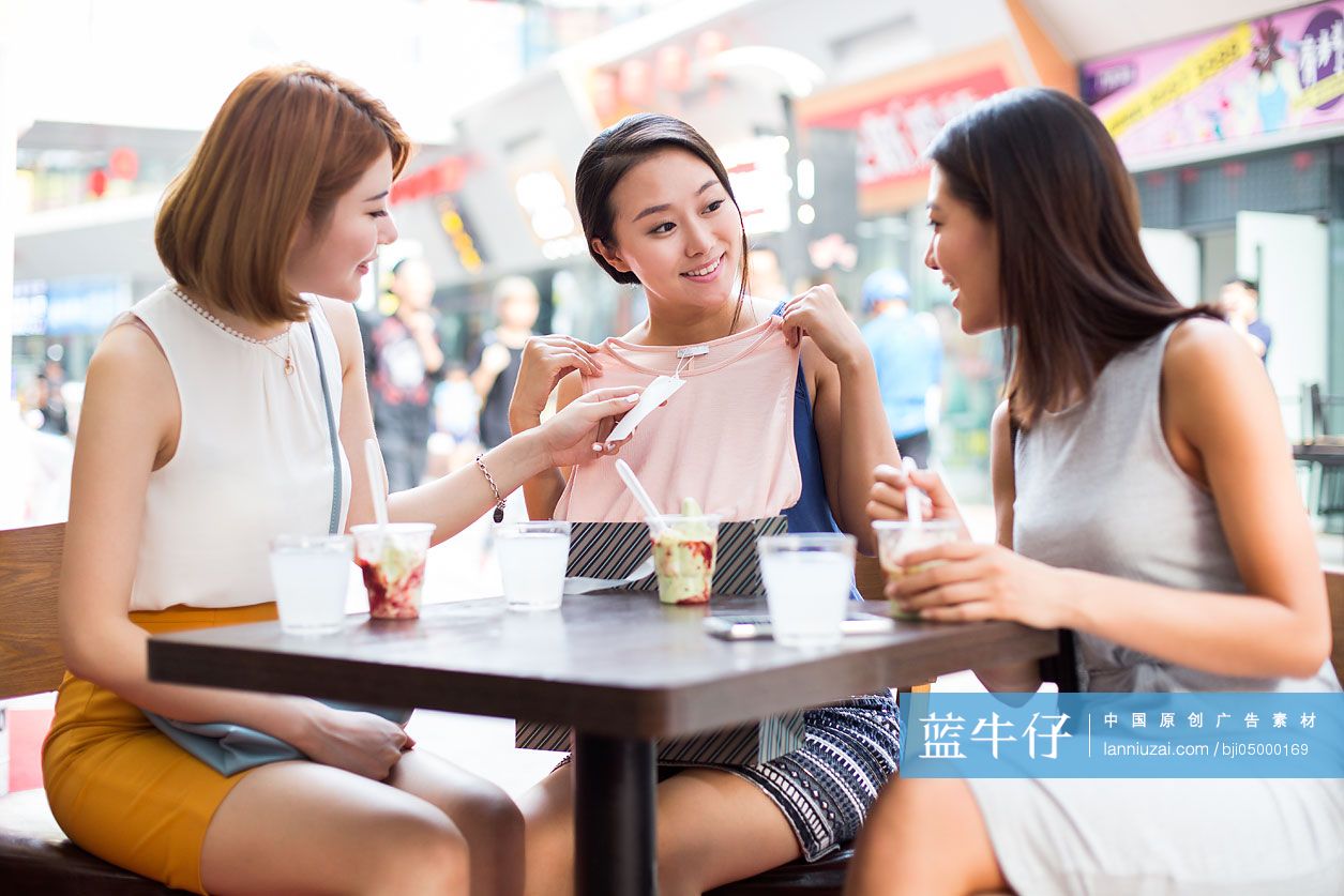 年轻闺蜜在露天咖啡馆聊天